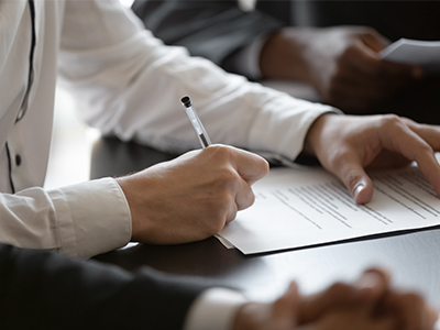 Close up of a person's hands while signing a contract