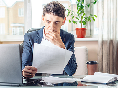 Man sitting at table looking at documents.