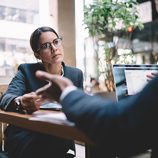 Female professional speaking with a colleague.