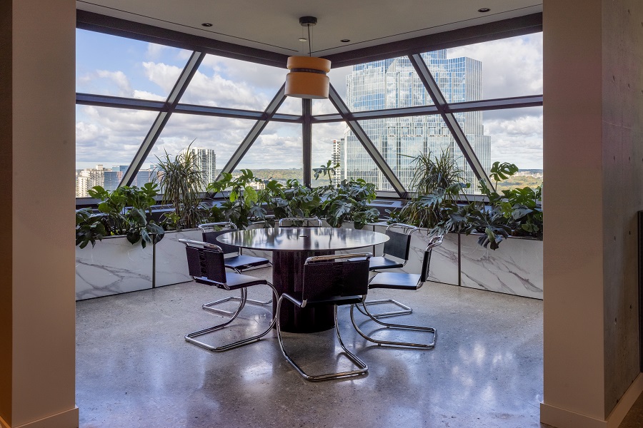 One of two rounded sunroom areas of The Plaza, Siskinds' lunch area, with a round table and six chairs at the center.