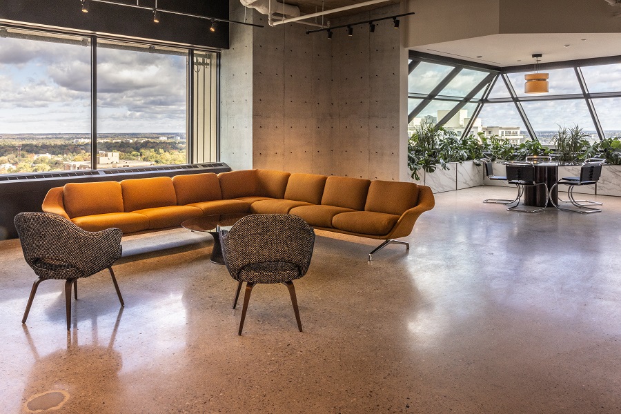 The Plaza - Siskinds' lunch area - including a sectional couch and two cushioned chairs in foreground. A rounded sunroom area in the background.