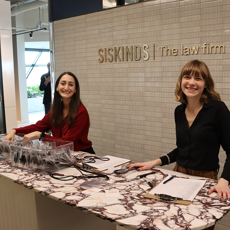 Articling students, Jordyn Liebman and Diana Stepner stand behind a counter top smiling.